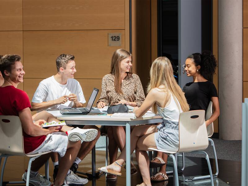 Schüler sitzen am Tisch im Gespräch