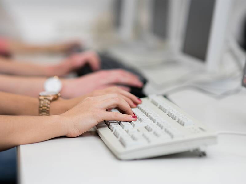 Ein paar Hände sind zu sehen, liegend auf einer Tastatur